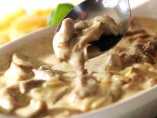 Mga kabute ng talaba sa sour cream sa isang kawali at sa oven: may mga sibuyas, patatas, baboy